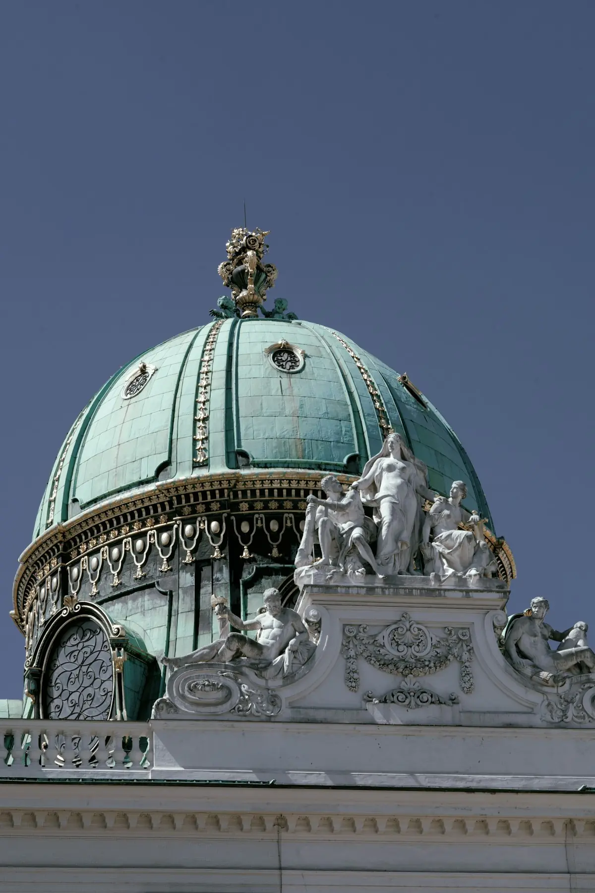 Grüne Kuppel eines historischen Gebäudes in Wien vor blauem Himmel